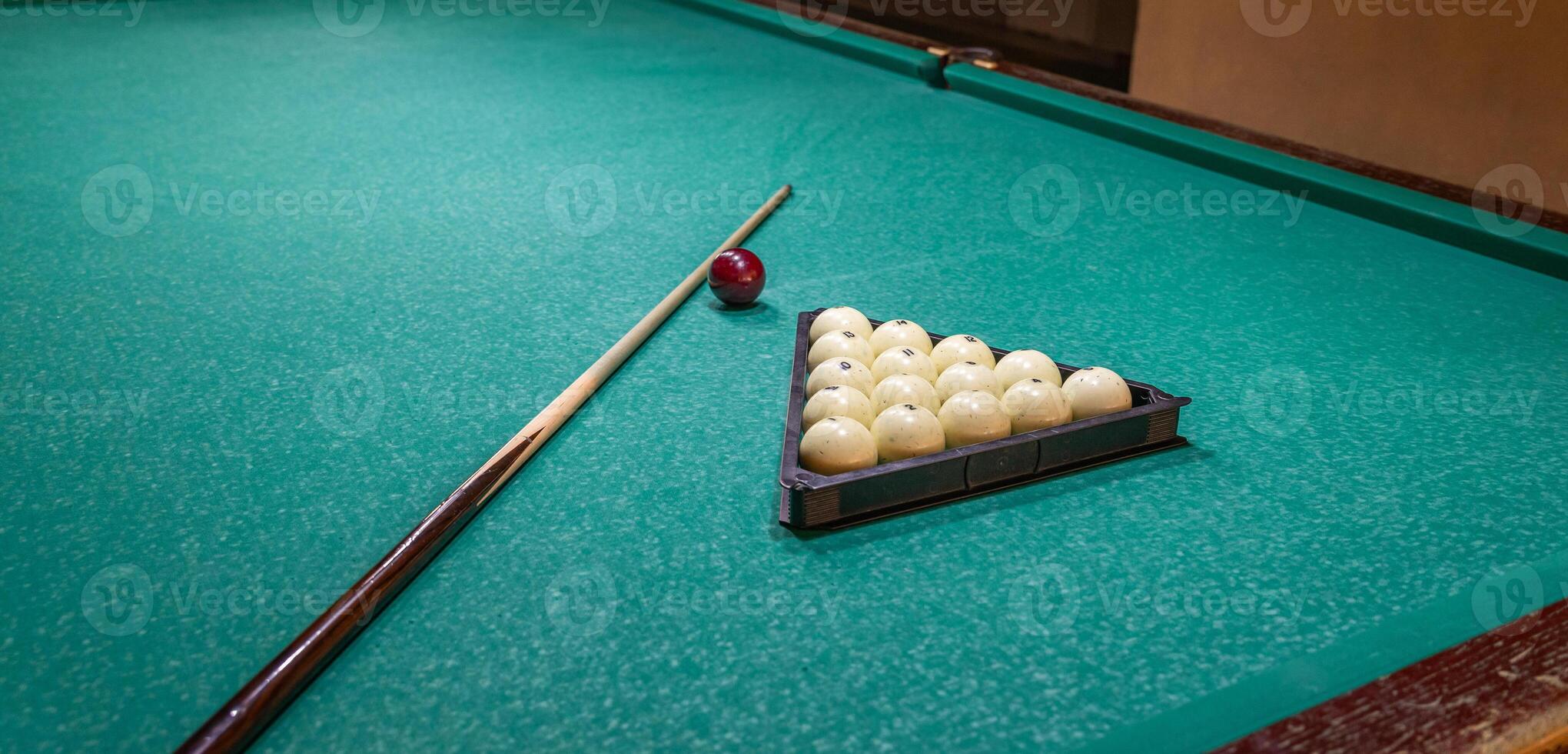 A billiard table with balls and a stick photo