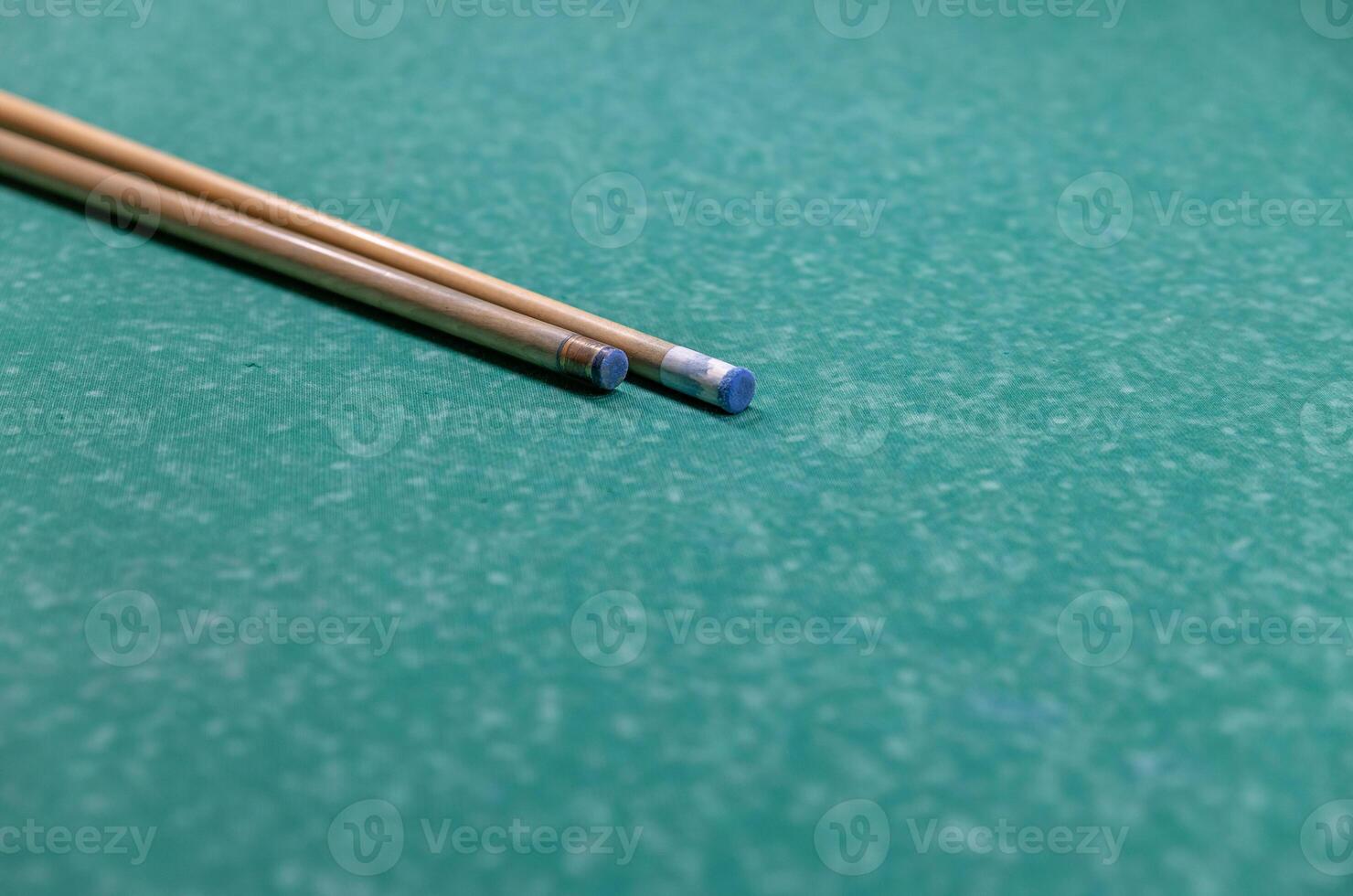 two wooden sticks on a green surface photo