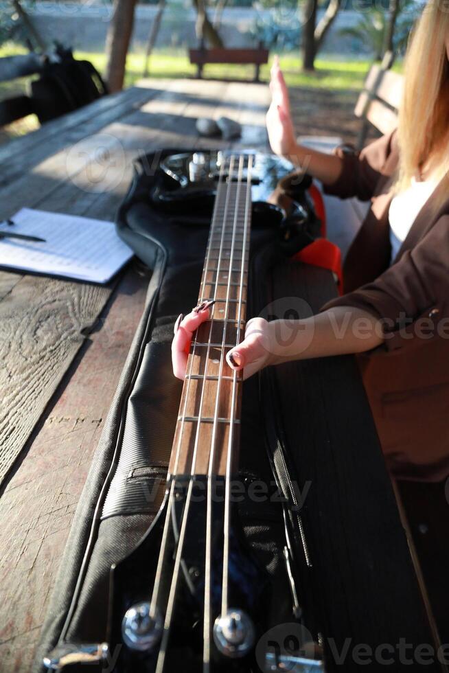 Girl Plays Bass Musical Instrument Sitting In Table In The Mountain Forest Vertical photo