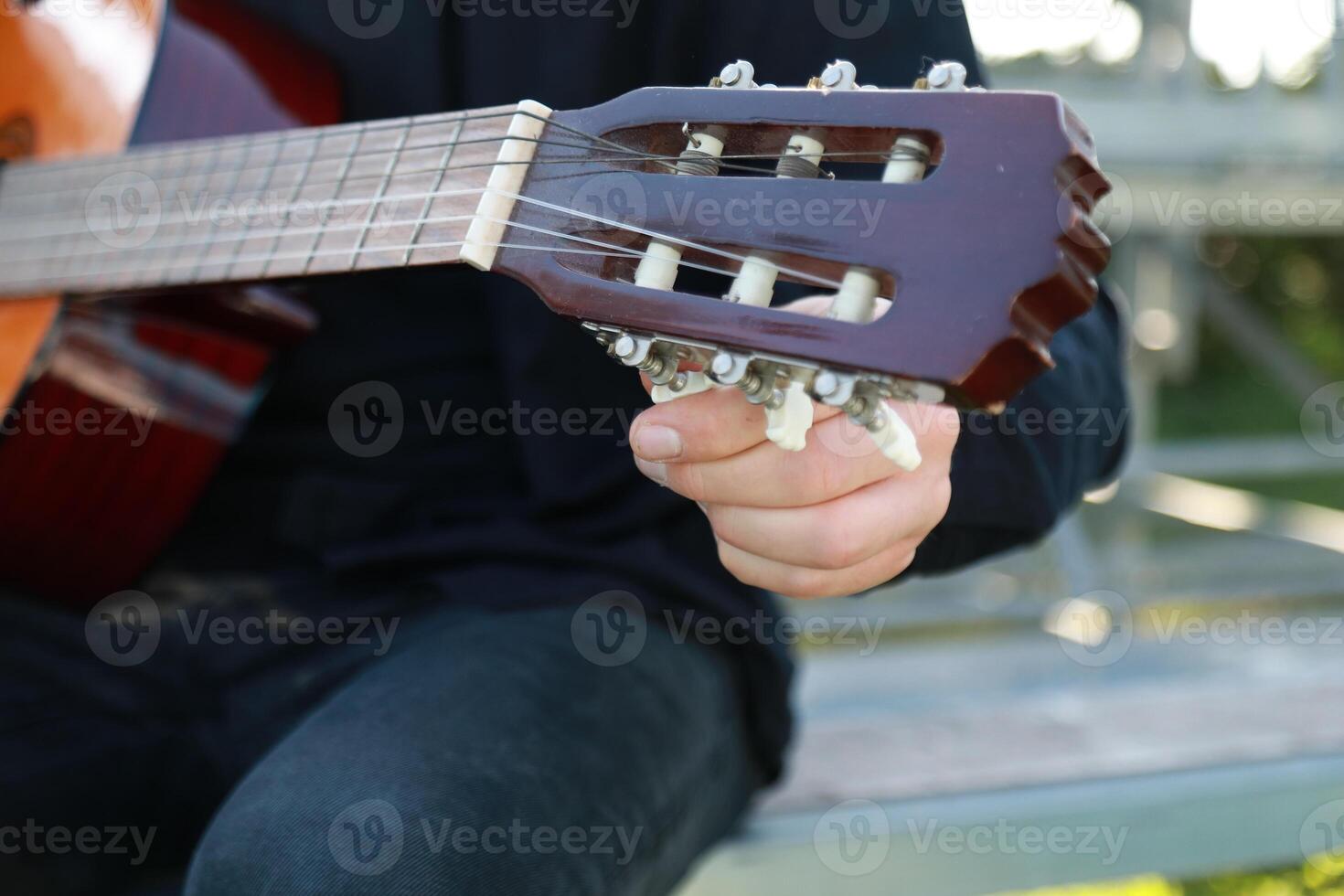 Hands Turns Wrench For Manual Tuning Of Classical Guitar photo