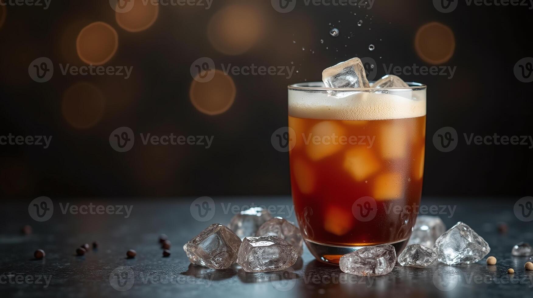 Icy amber beverage in a glass with scattered ice cubes and bokeh background. photo