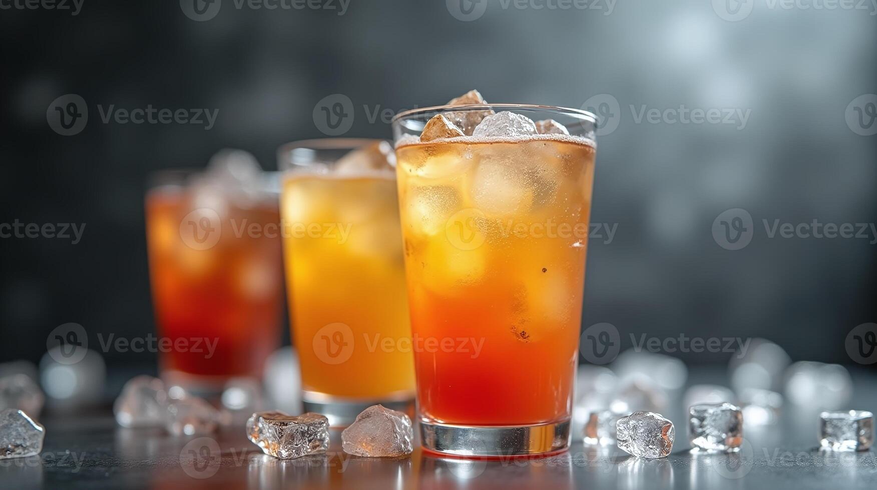 Three glasses of refreshing beverages with ice cubes, against a blurred background. photo