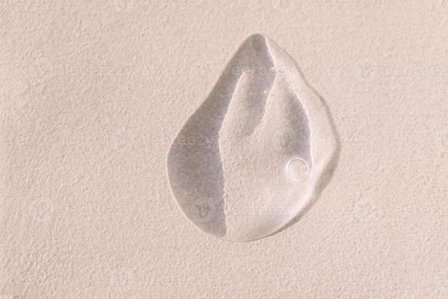 Close-up of a transparent gel smear with bubbles. Cosmetic products. A drop of serum or essence on a textured background. Bright sunlight. photo