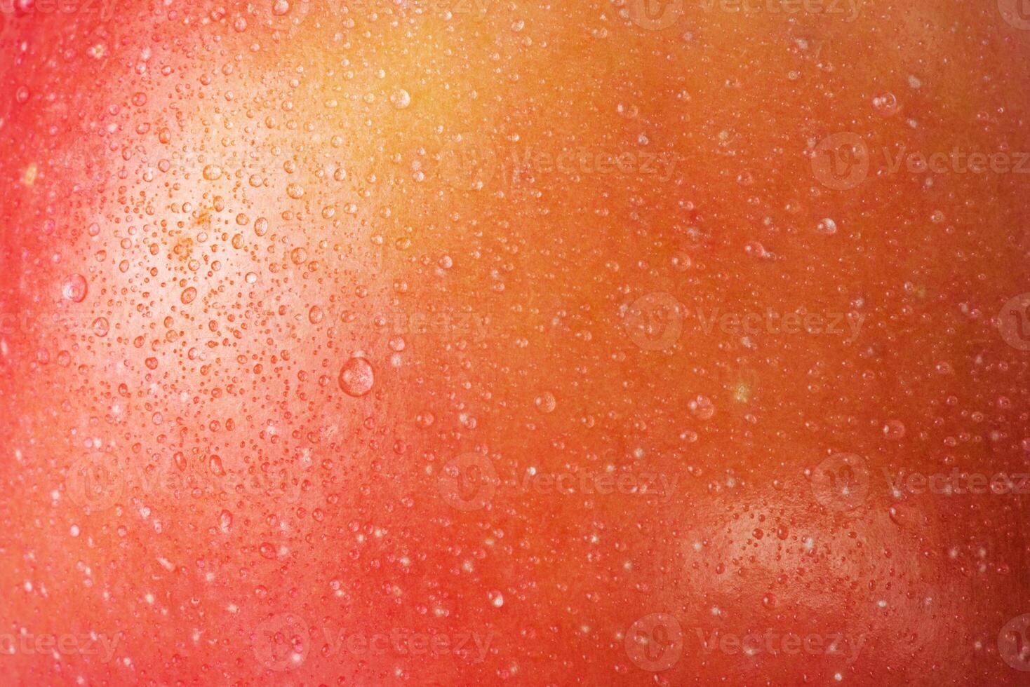 Red with yellow color apple skin macro photo as background. Texture of apple with water drops.