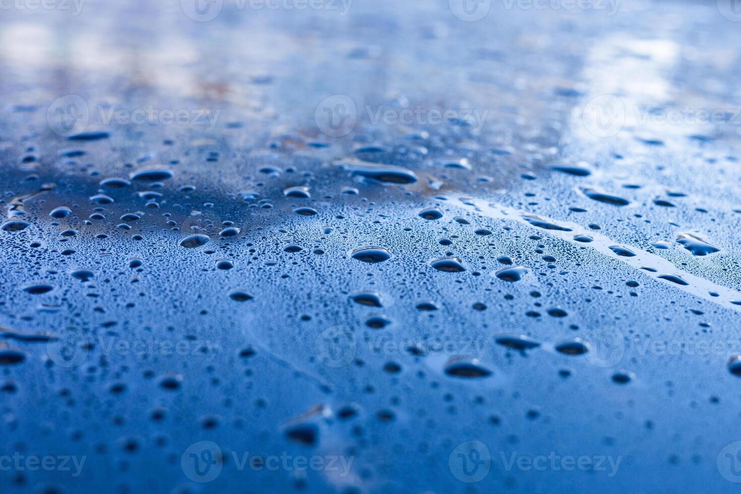 Water droplets accumulate on a blue surface after rainfall during the early morning hours photo