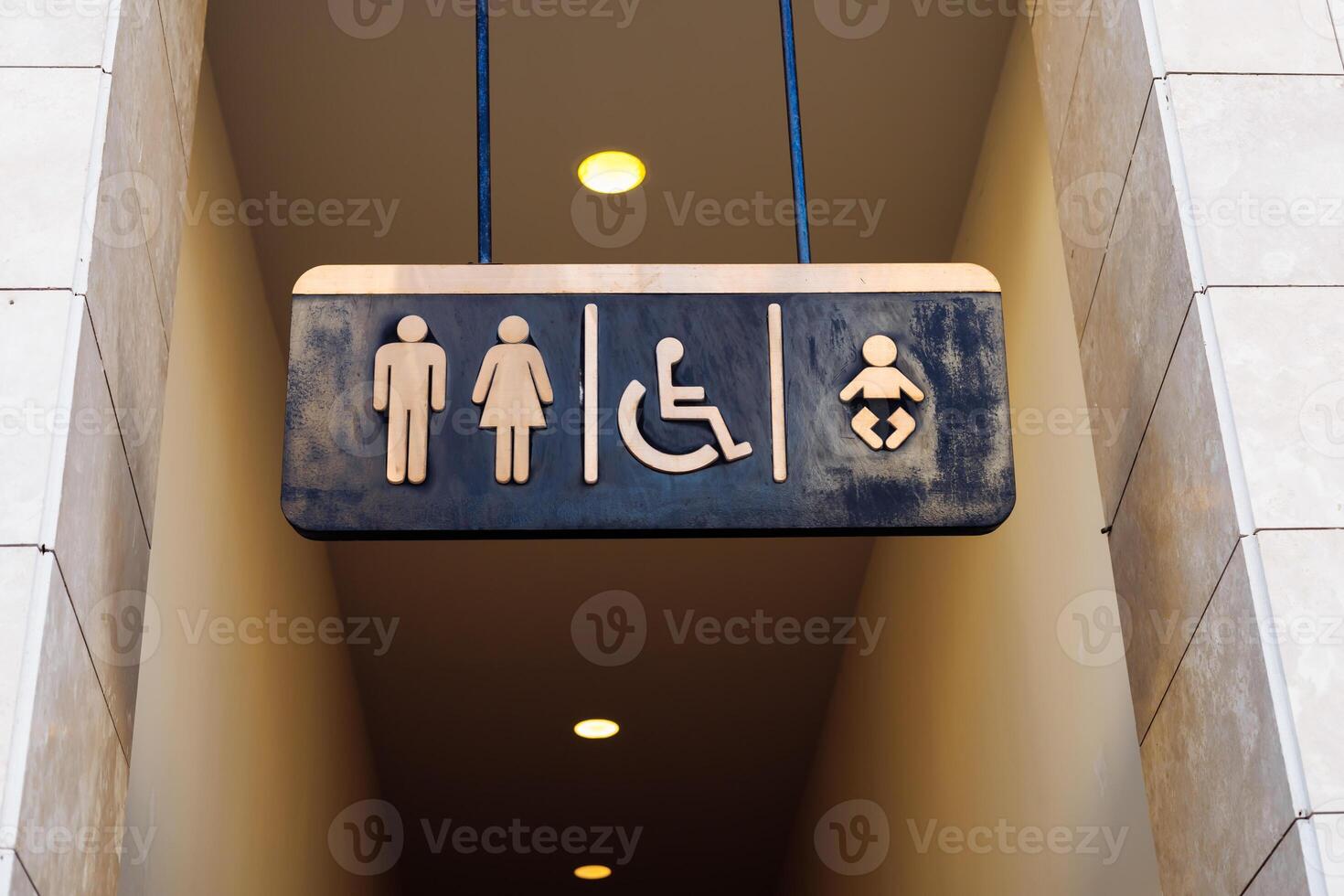 Restroom sign displaying symbols for men, women, disabled, and baby changing in public space photo