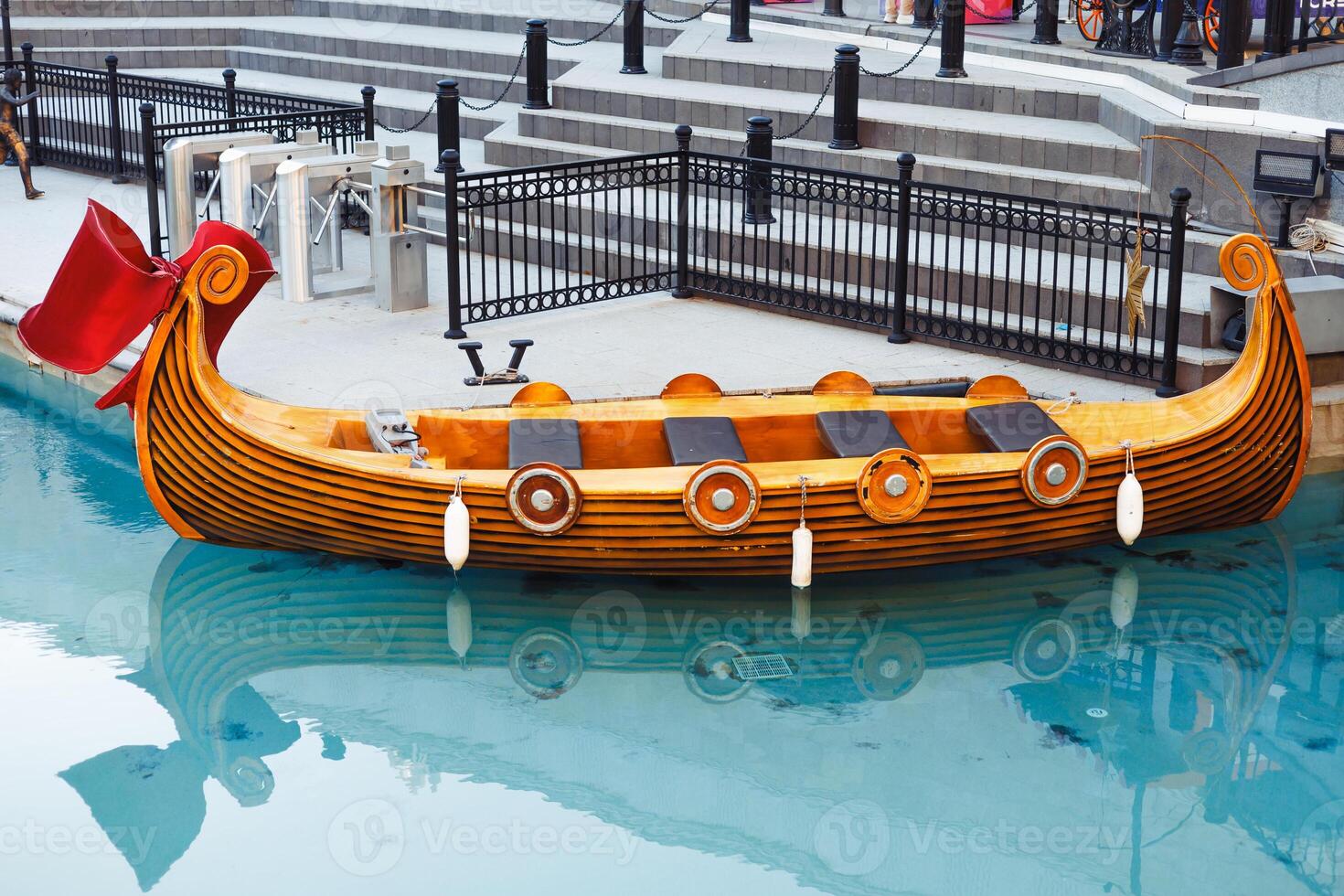 An empty fairy-tail boat gondola waits for tourists on a narrow canal photo