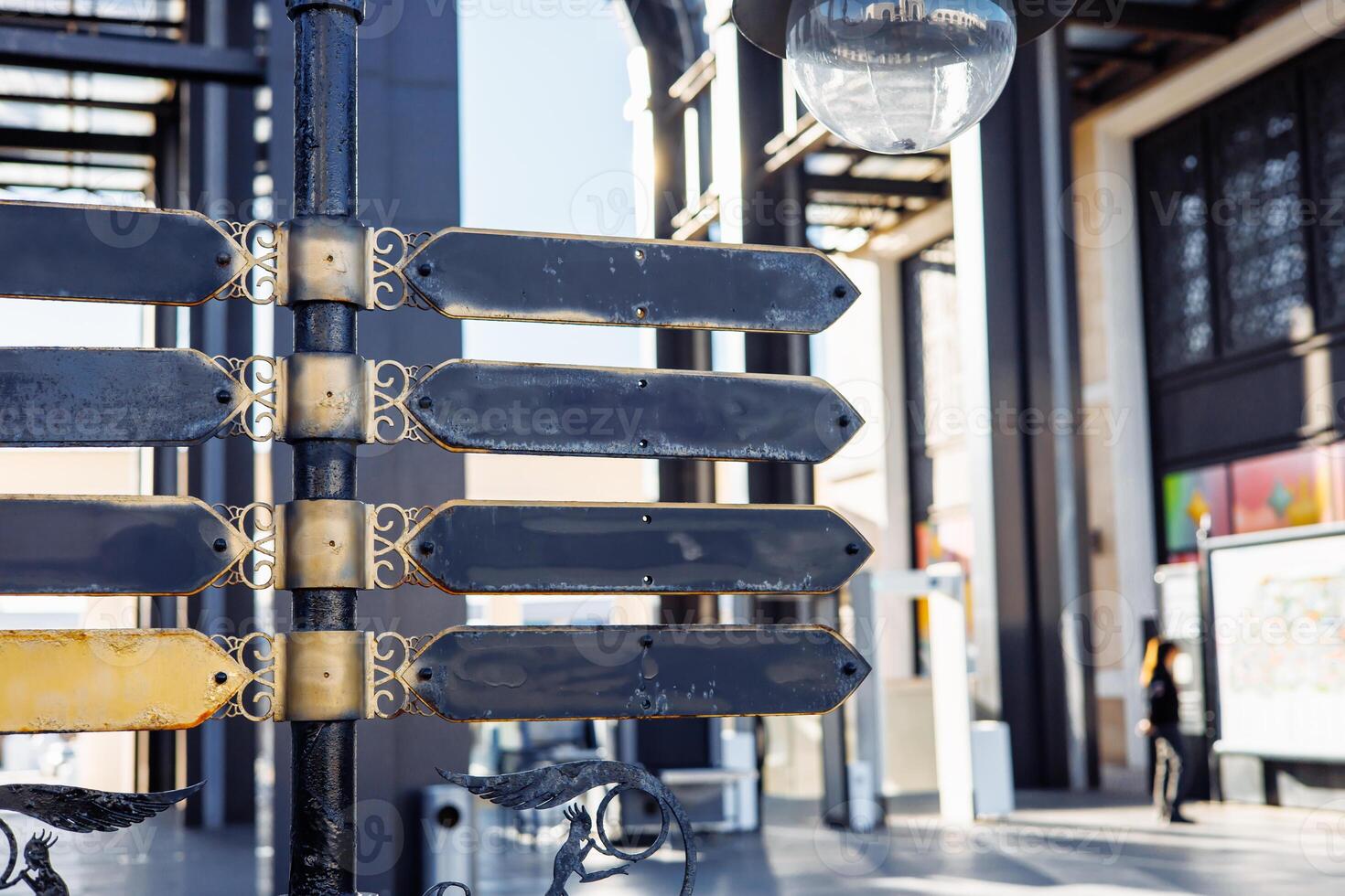 Blank directional sign with decorative elements in urban setting during daylight hours photo