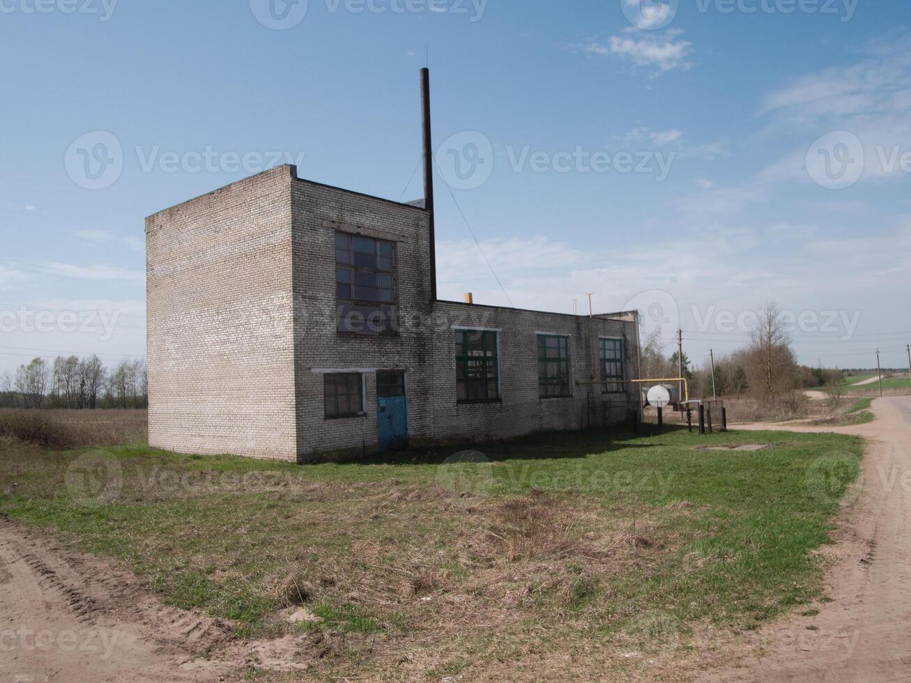An old and abandoned industrial building remains isolated in a serene and peaceful rural environment photo