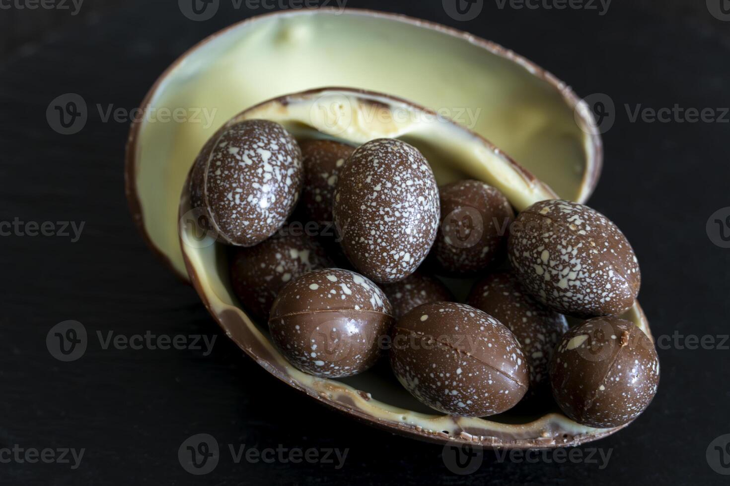 Sweet dessert of Easter egg stuffed with chocolate candies. photo
