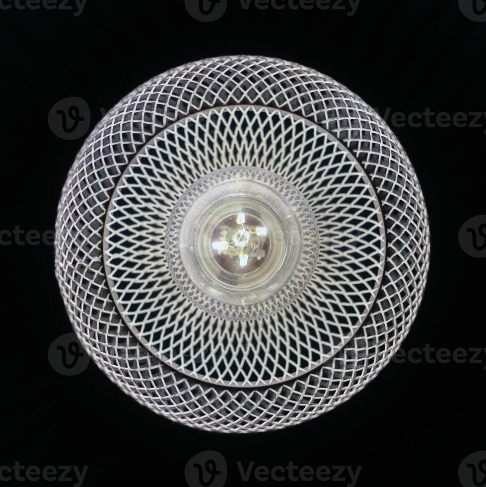 patterned light chandelier with light bulb on black background photo