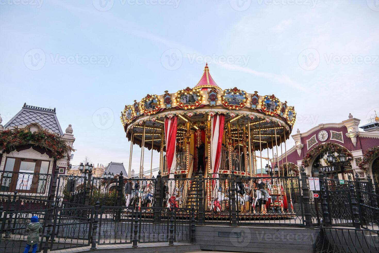 Moscow, Russia, 31.03.2025 A carousel with a red and white top is surrounded by a fence photo