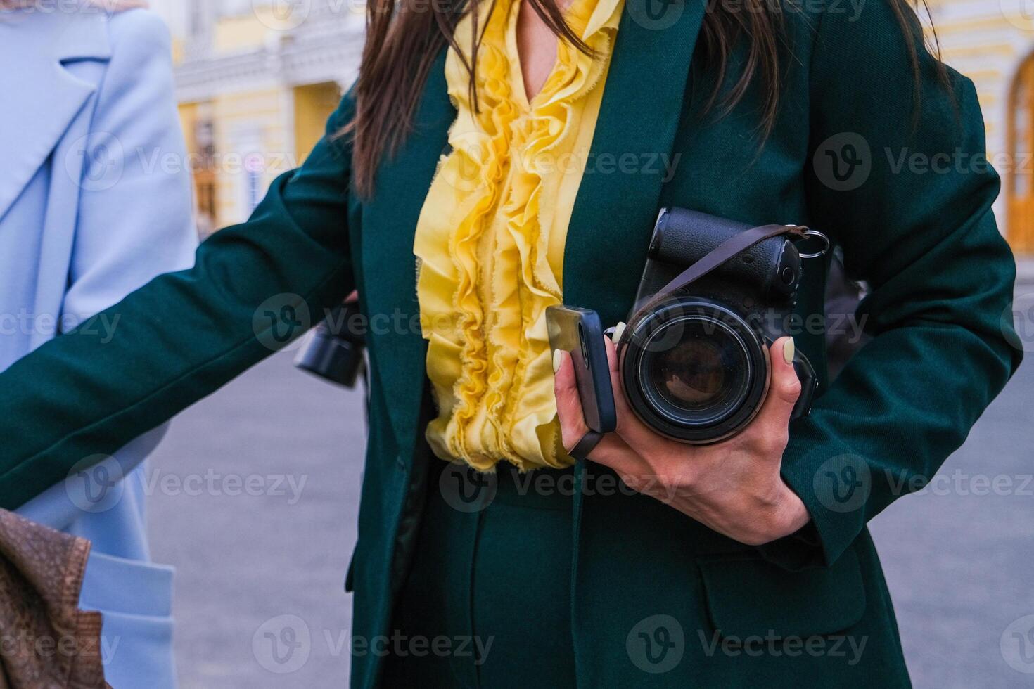 Moscow, Russia, 31.03.2025 A woman in a green jacket and yellow blouse is holding a camera photo