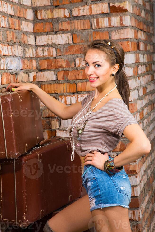 A woman is posing in front of a stack of suitcases photo