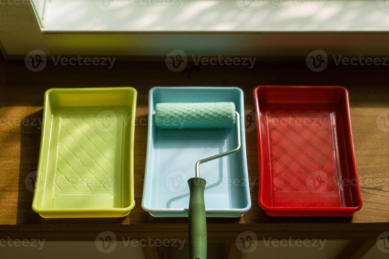 Paint roller and tray in red, blue and green getting ready to paint photo