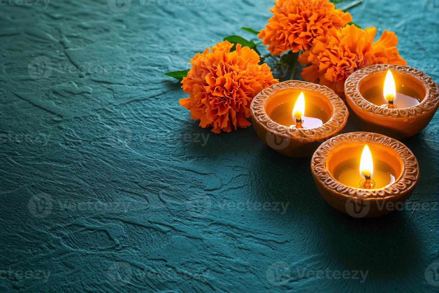 Burning diyas and marigold flowers celebrating diwali festival on teal background photo
