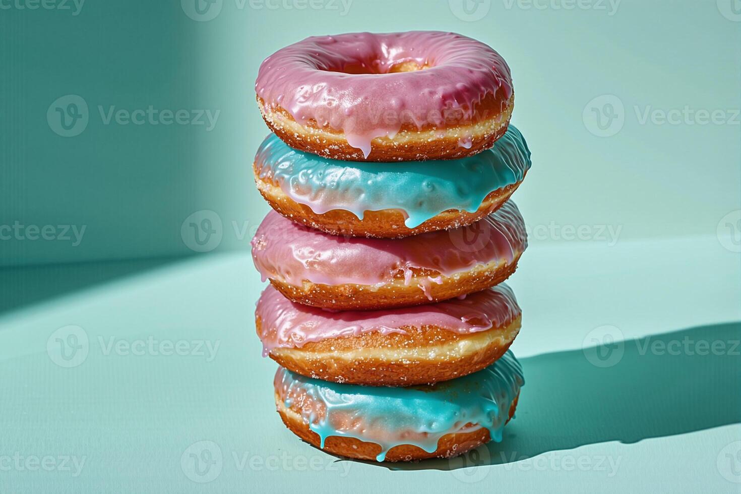 Stack of pink and blue glazed donuts creating a vibrant contrast photo