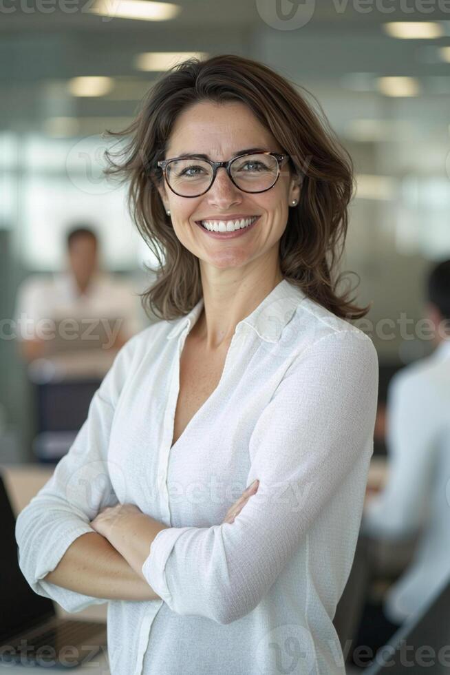 Smiling businesswoman with crossed arms in modern office photo