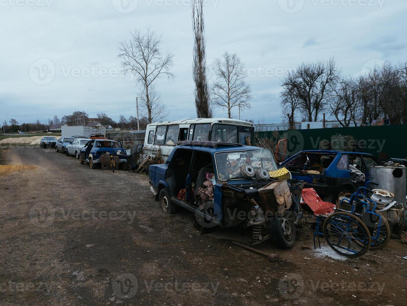 Rusty broken remnants of cars and buses at scrapyard. photo