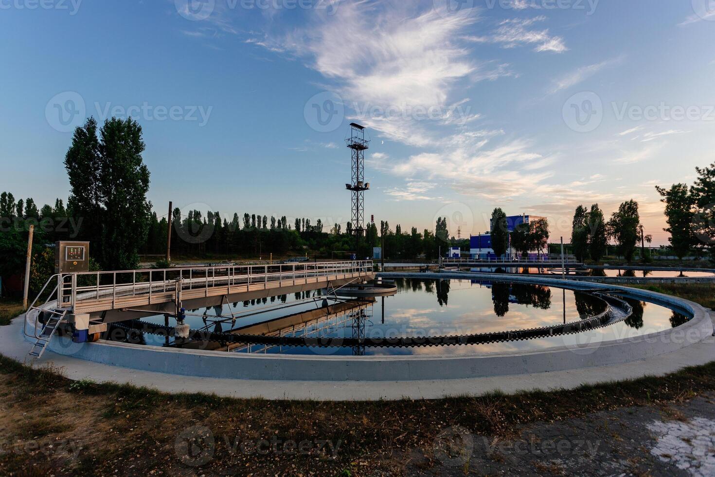 Modern sewage treatment plant. Round wastewater purification tanks at sunset. photo