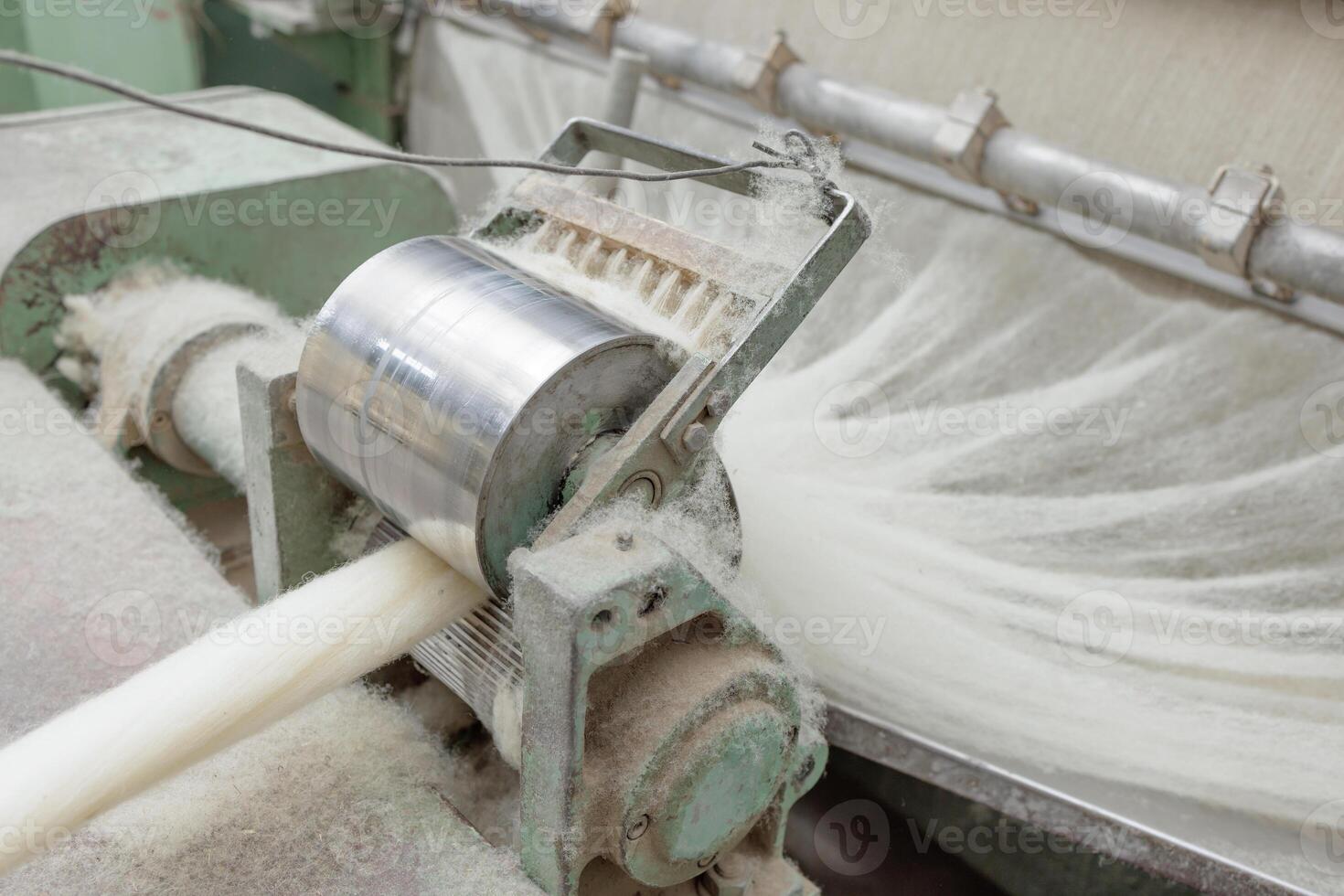 Wool fibers enter a carding machine at a textile plant for further yarn production. photo