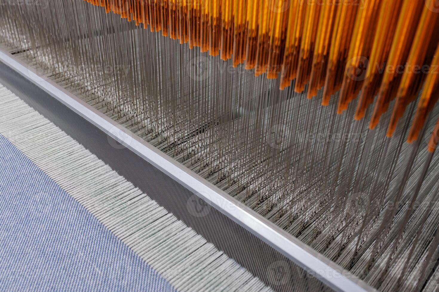 Detail of textile weaving machine with threads, loom operation in fabric manufacturing process. photo