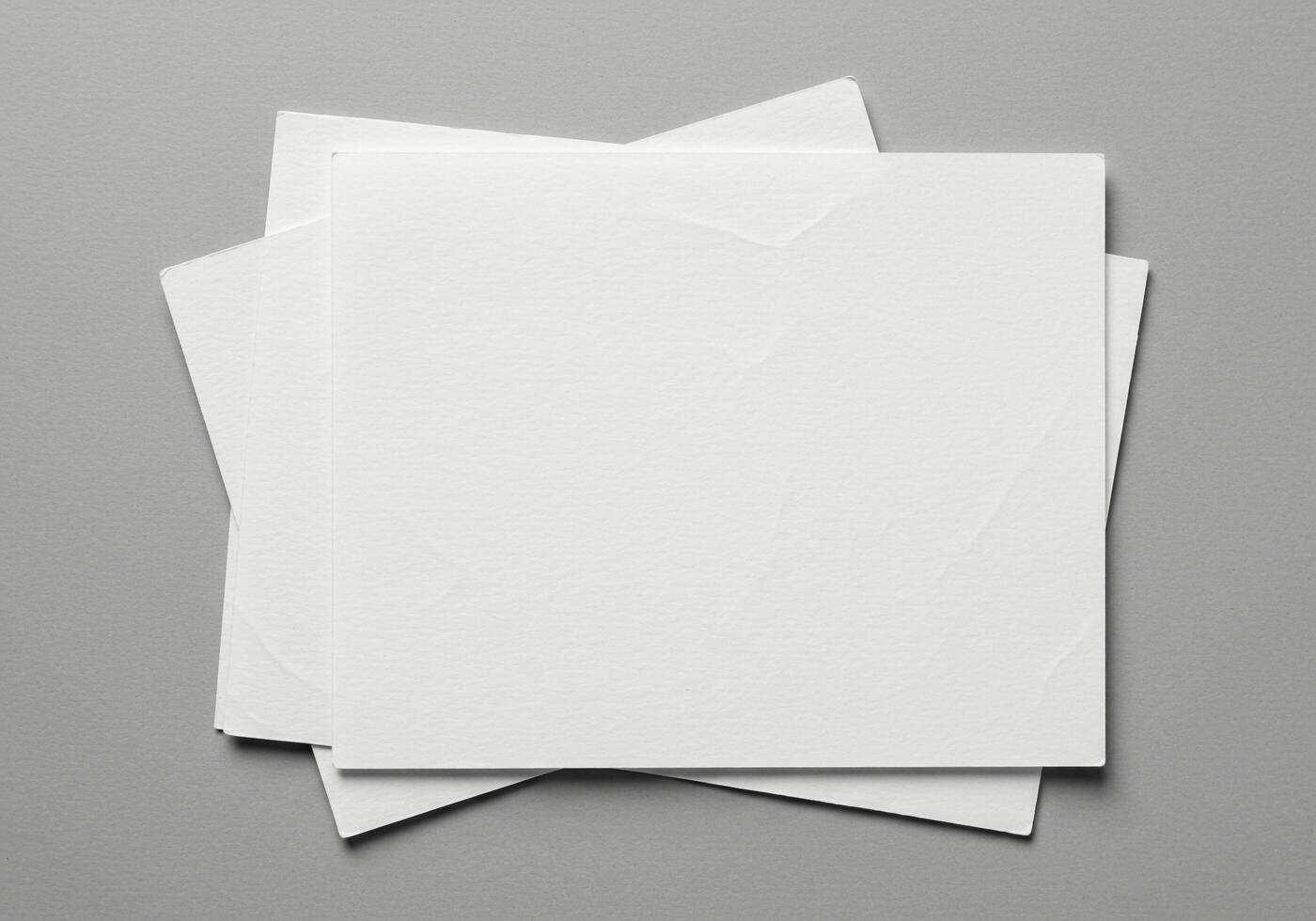 Three blank white paper sheets on a gray background photo