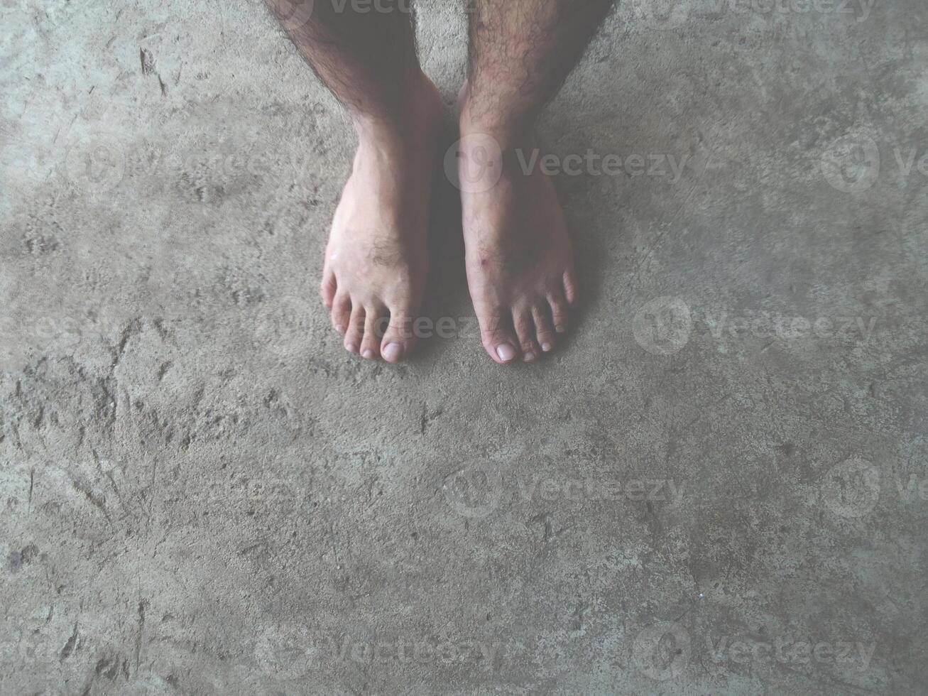 bare feet of man on cement floor photo