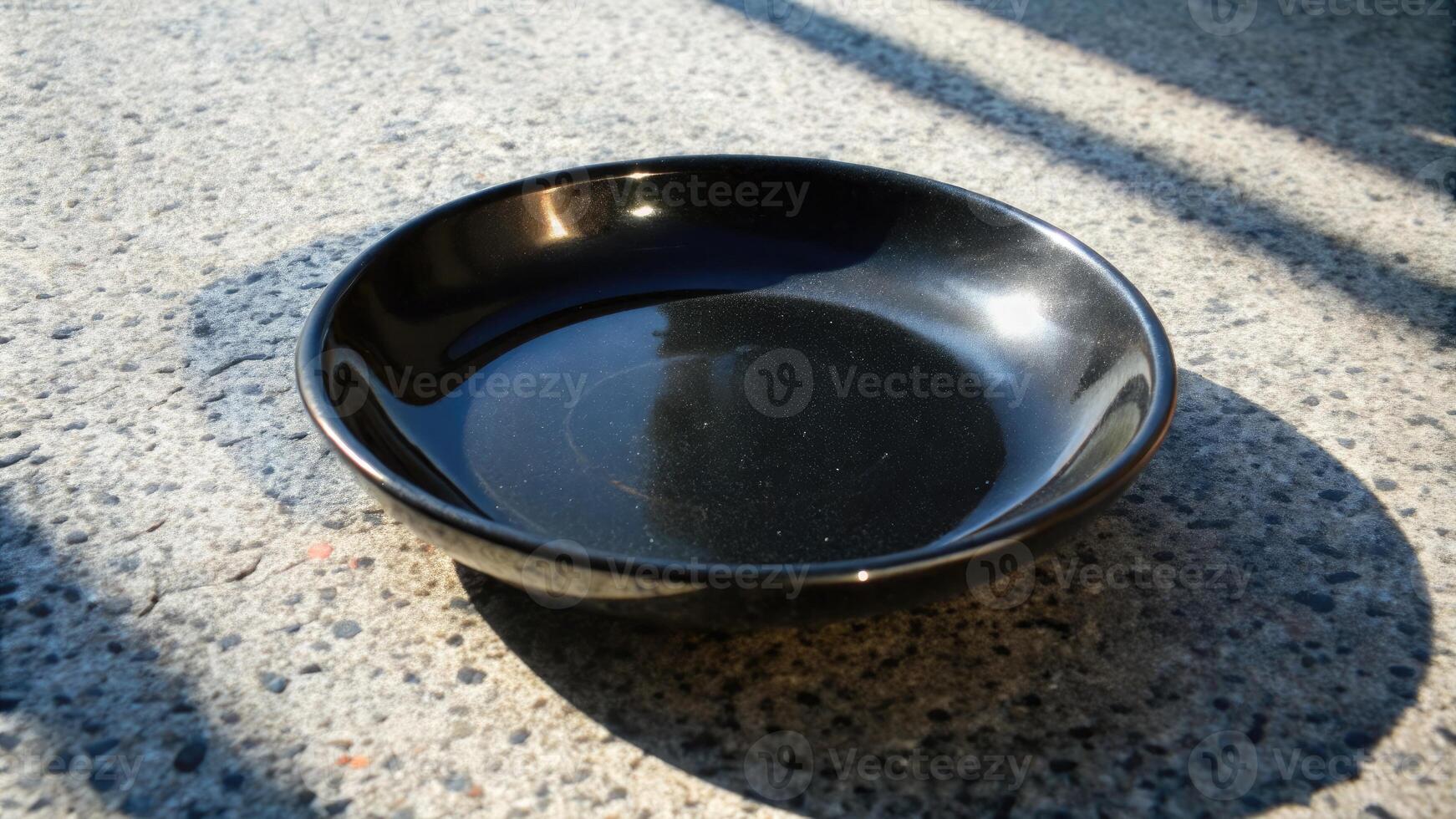 Matte black bowl on a textured stone surface. photo