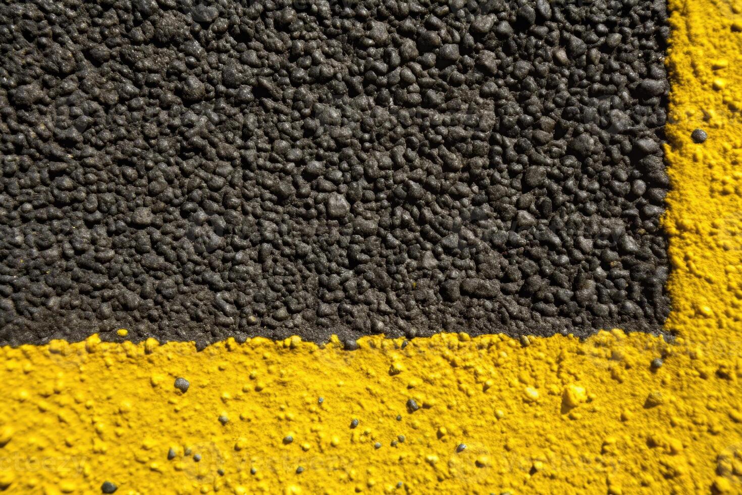 Close-up of textured asphalt with a bold yellow line. photo