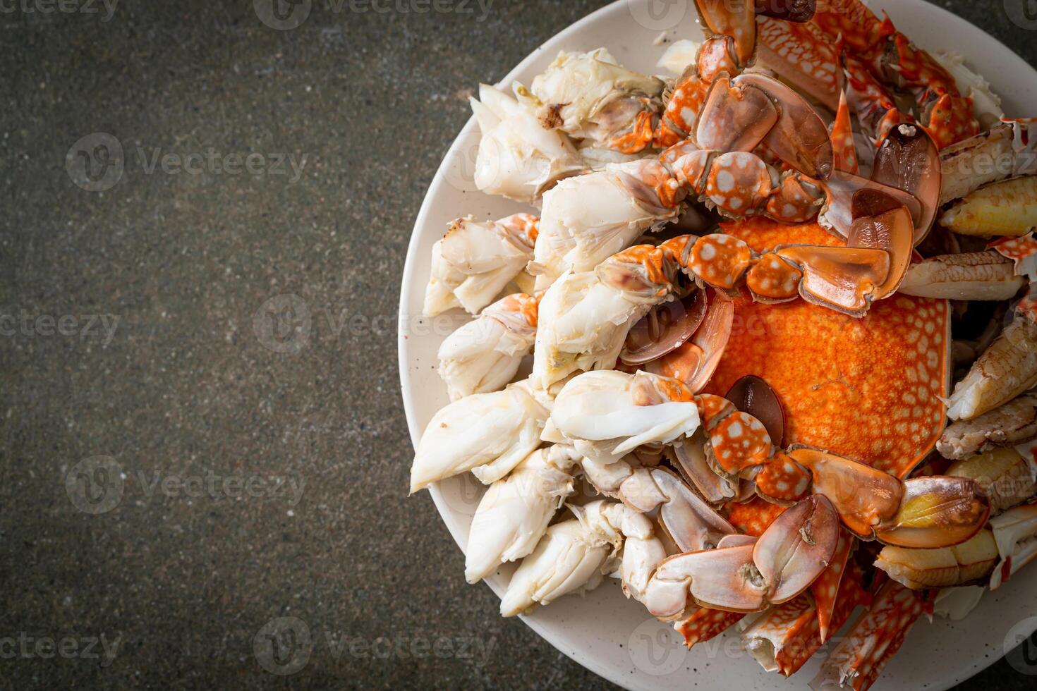 Steamed blue crab with spicy seafood sauce on dark background photo