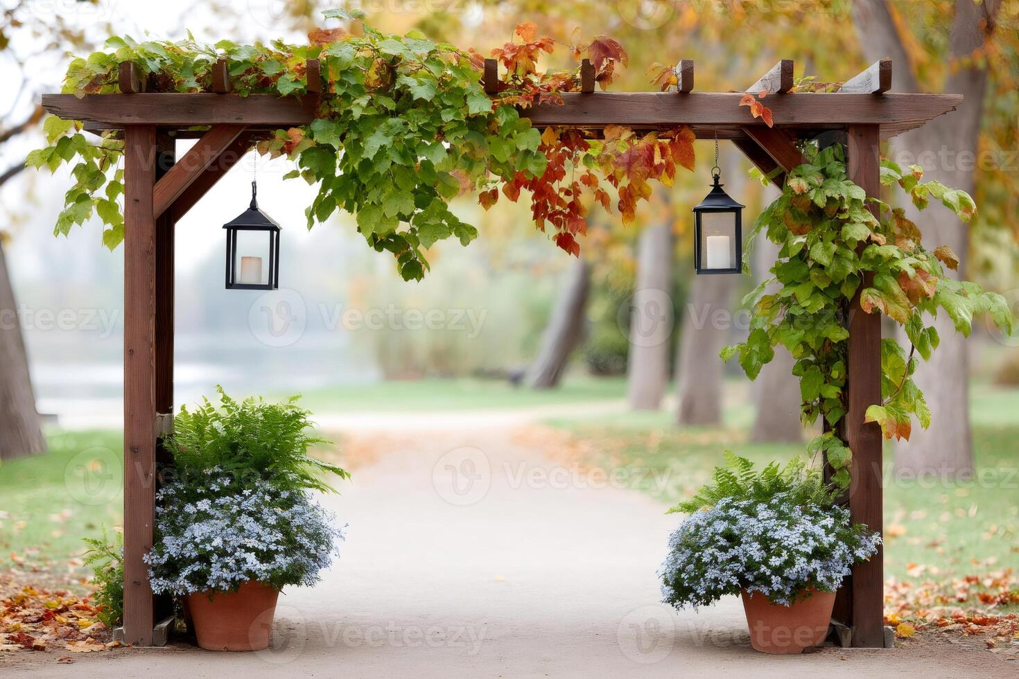 Wooden arch with hanging lanterns illuminating a path in a park during autumn photo