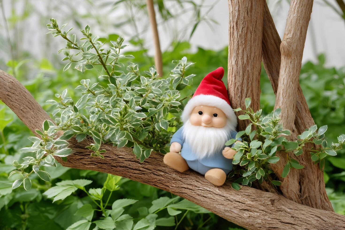 Garden gnome sitting on a tree branch surrounded by green leaves photo