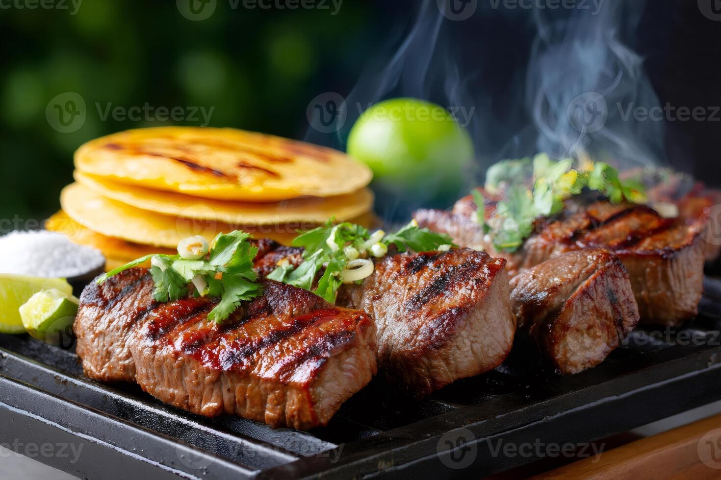 Smoking hot grilled beef steaks with tortillas, lime and cilantro garnish photo
