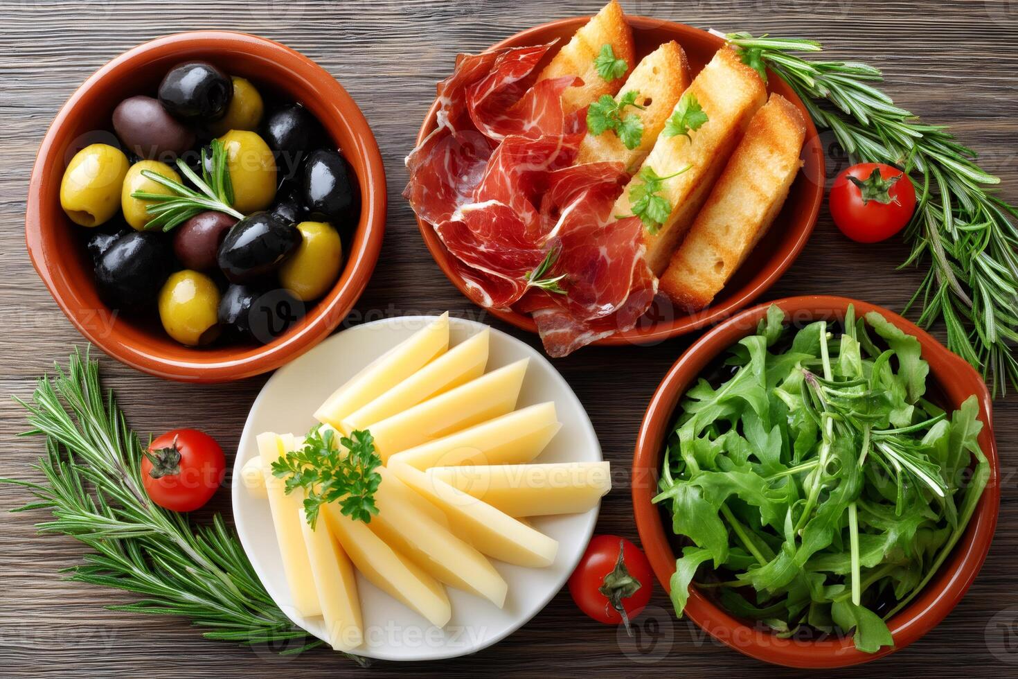 Spanish tapas with cheese, olives, Iberian ham and rocket salad decorating a wooden table photo