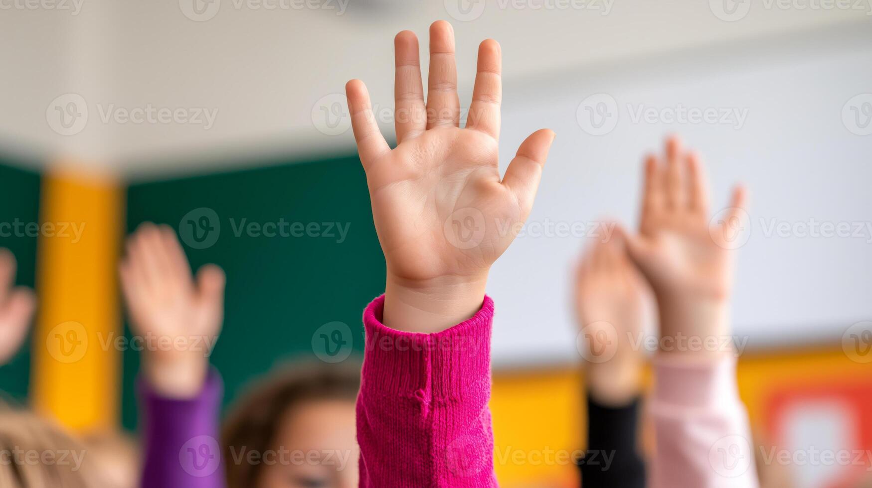 Several children's hands are raised, showcasing diverse skin tones. The foreground features a pink-sleeved hand, while others wear purple and beige sleeves. photo