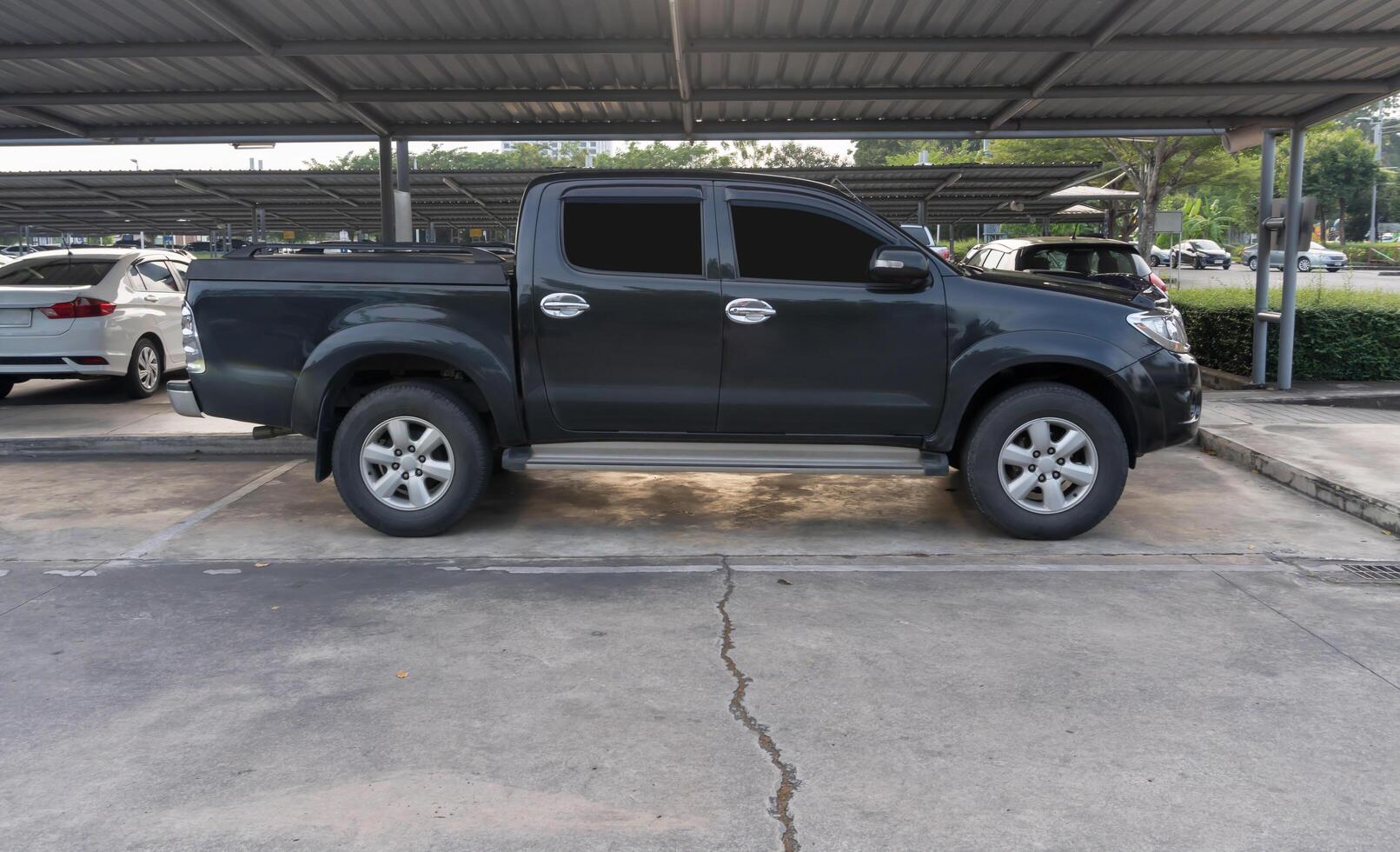 Black pickup truck with right side view parking at open area parking lot with roof of a department store photo