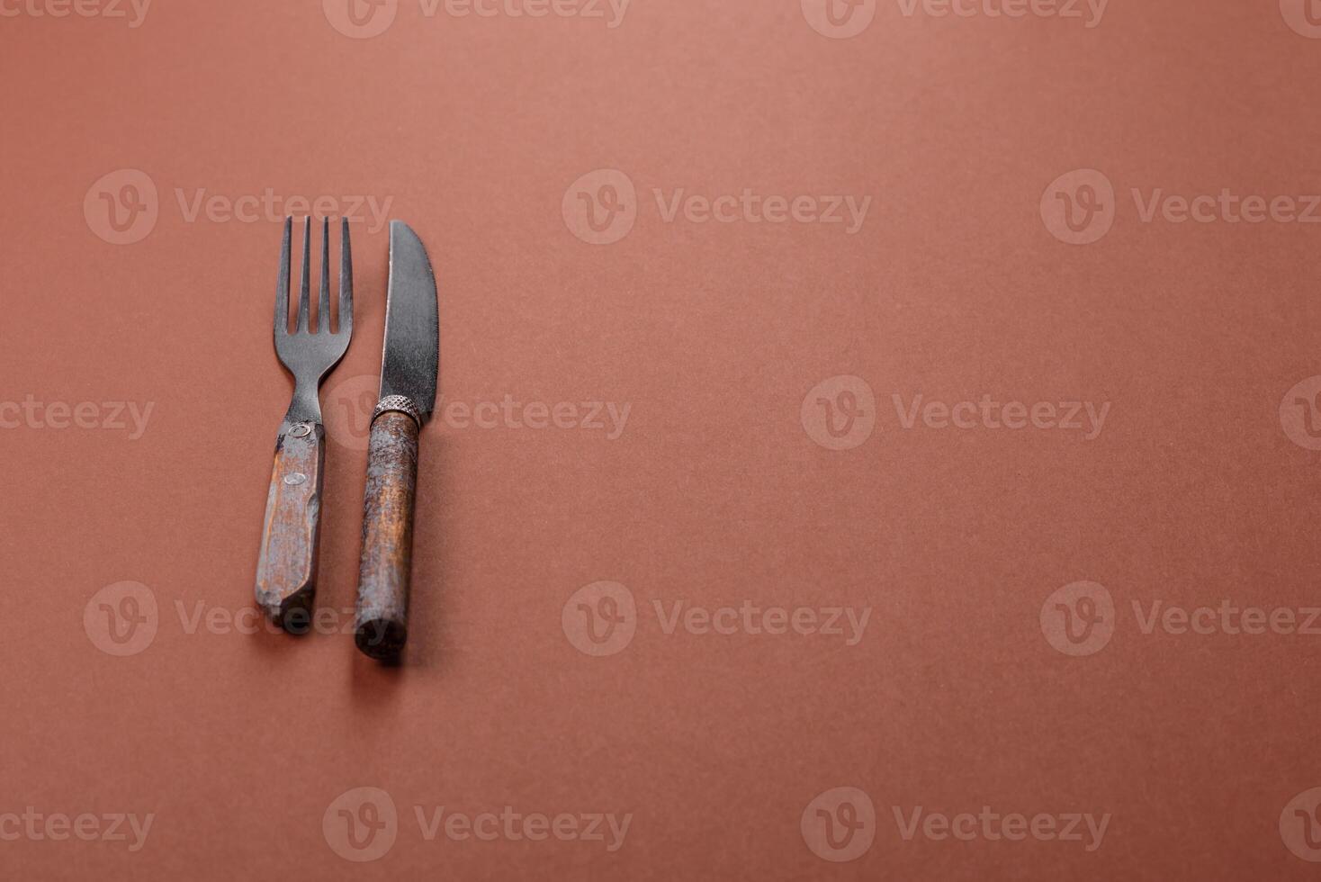 Knife and fork on a brown table photo
