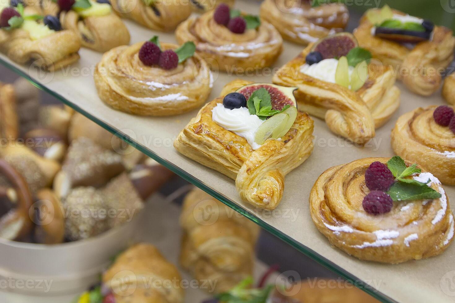 Delicious baking with berries and custard cream in glass showcase photo
