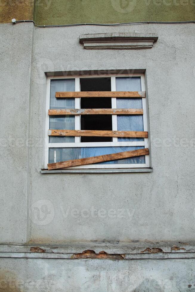 A boarded-up plastic window in an old, abandoned, crumbling building photo