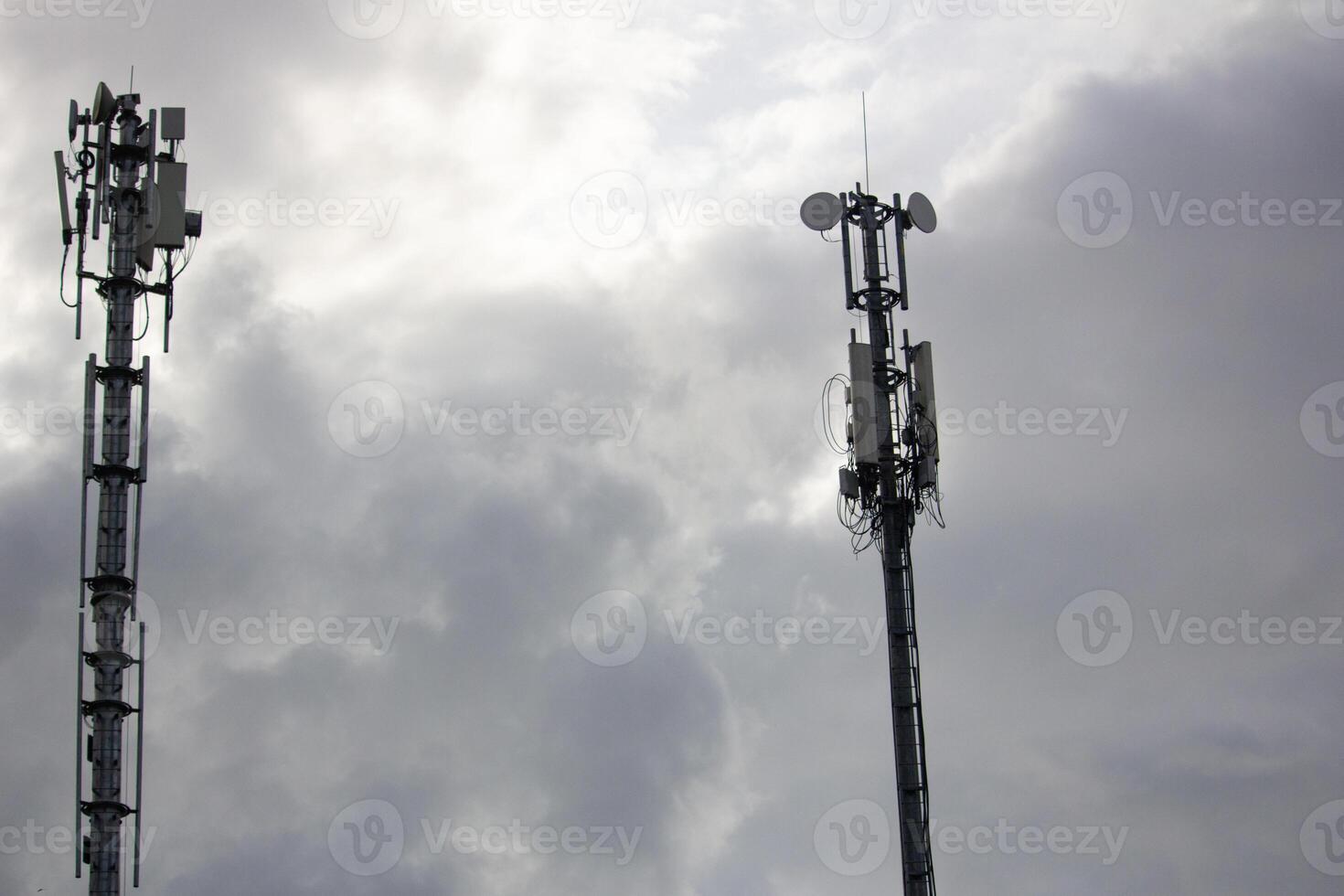 Two telecommunication towers under a cloudy sky, symbolizing connectivity, communication, and modern infrastructure technology photo