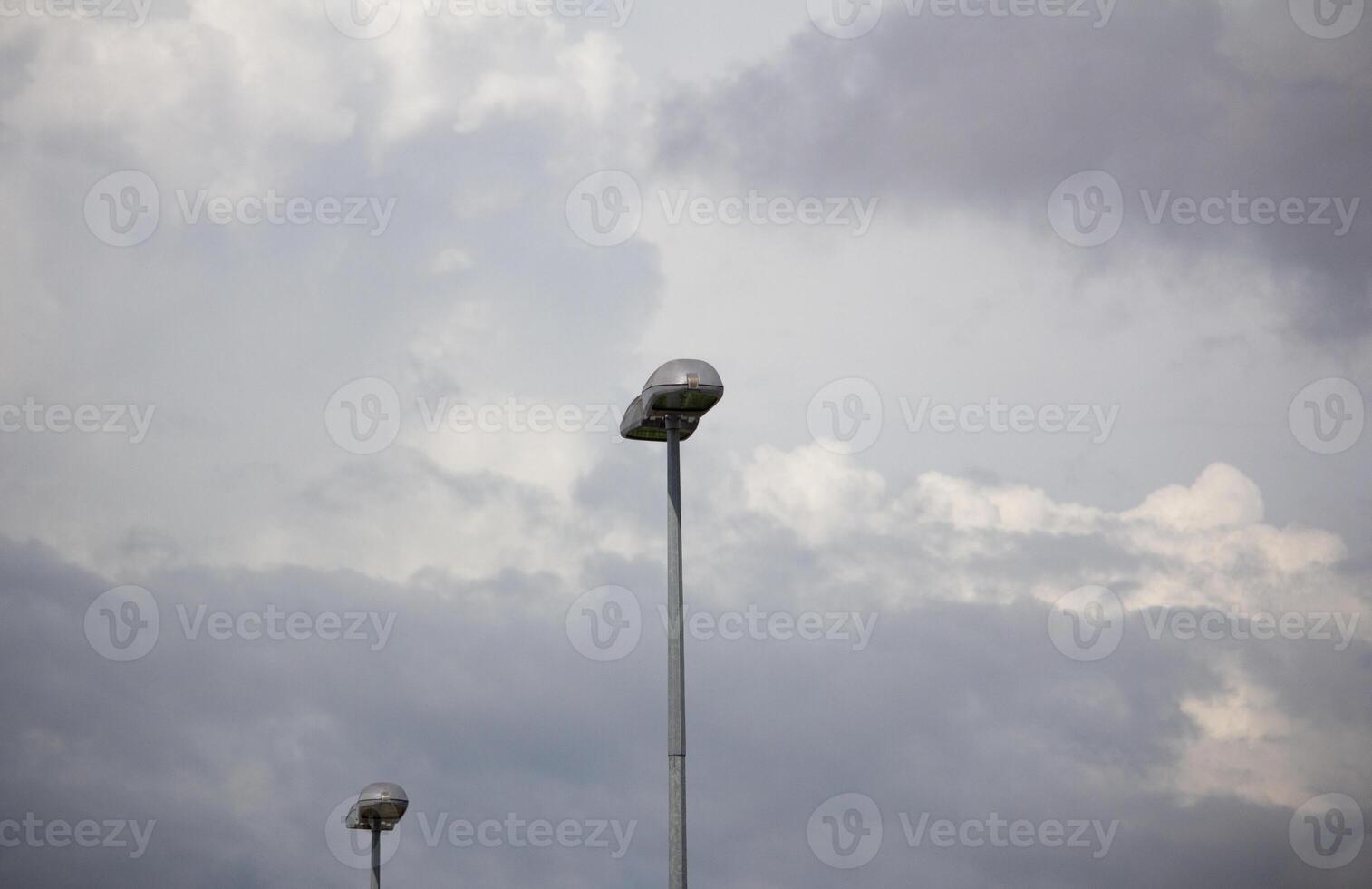 Urban street lights under dramatic cloudy sky, showcasing contrast and atmosphere in a minimal cityscape composition photo