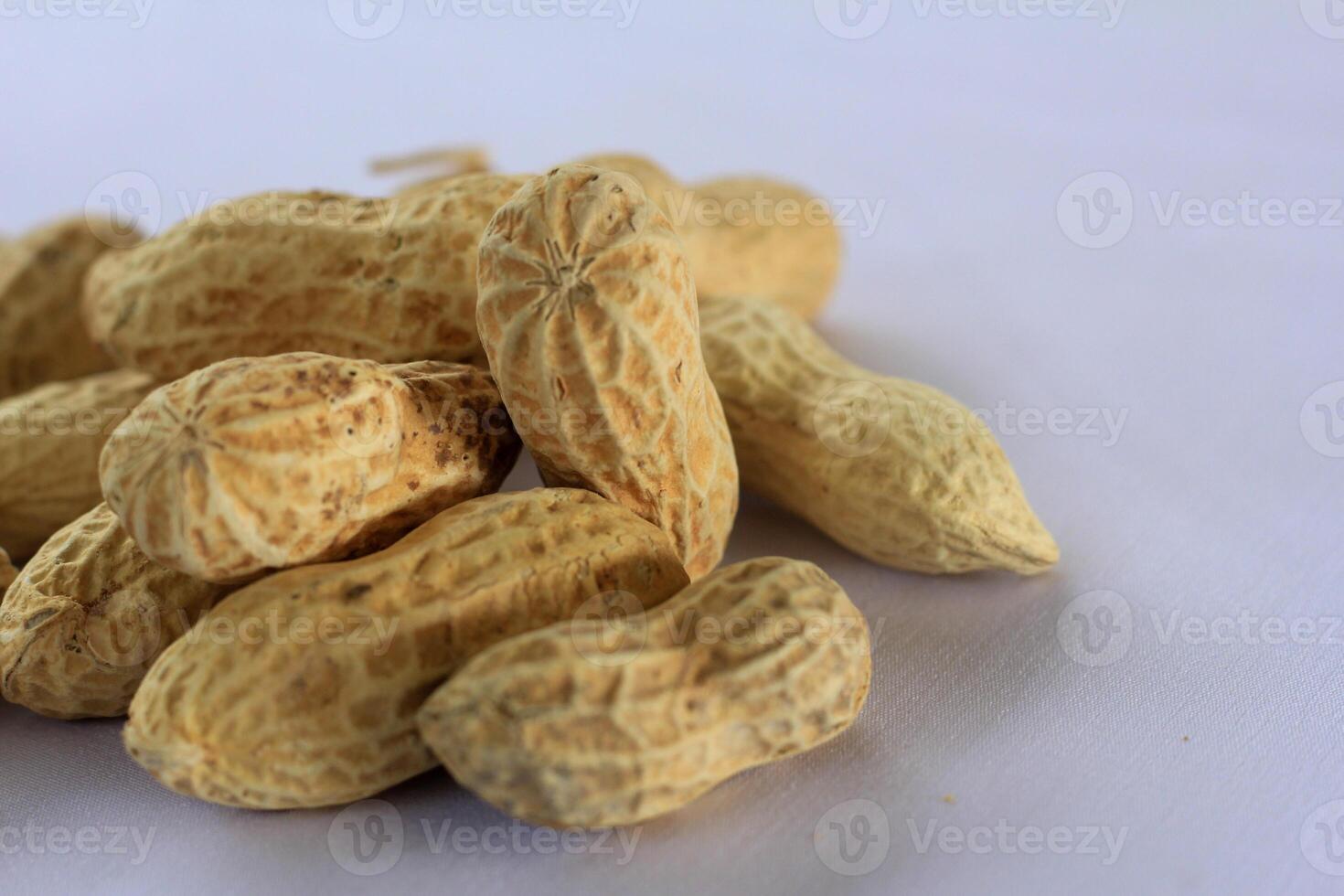 Organic peanuts in shell isolated on clean white studio backdrop photo