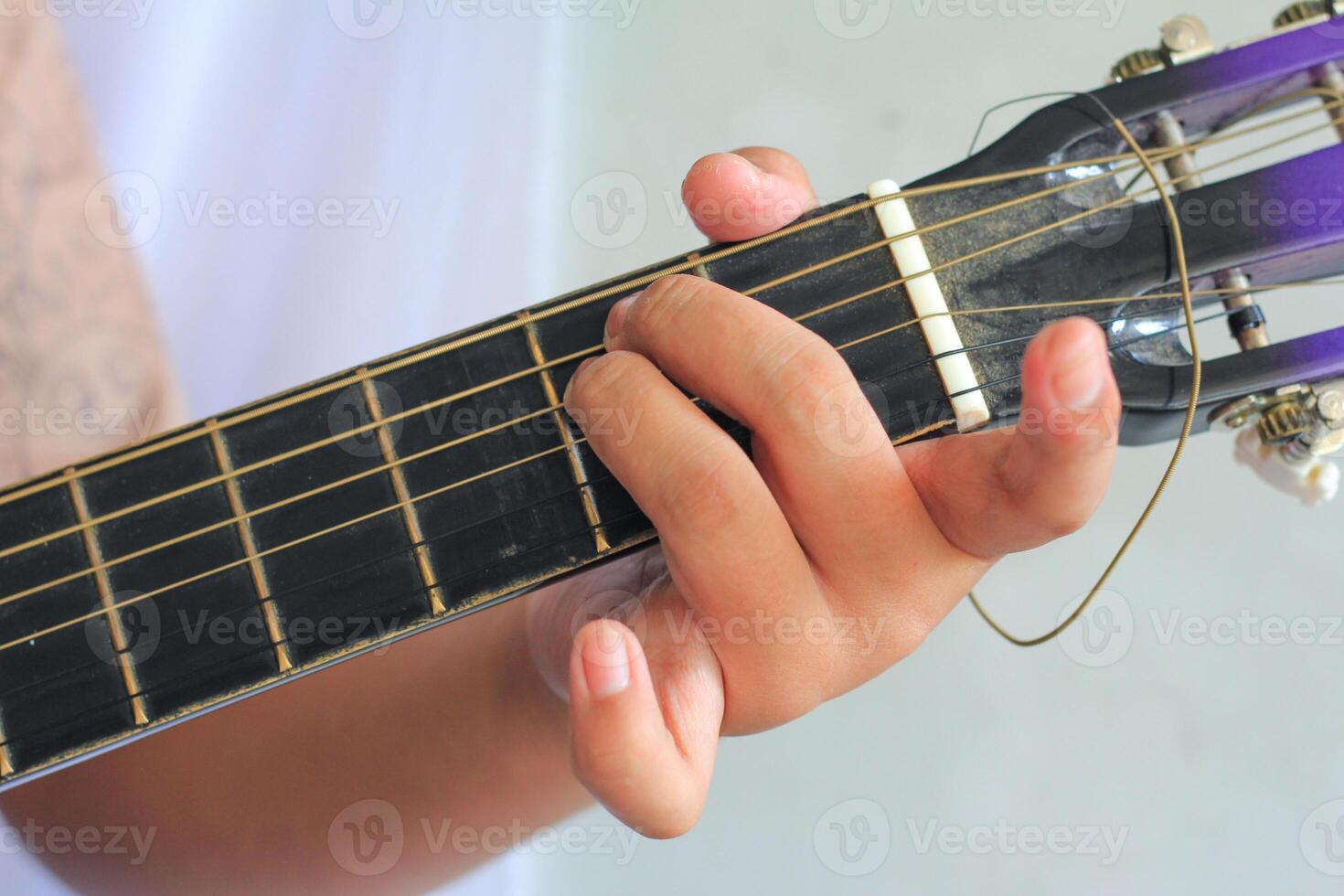 Fingers Accurately Pressing Frets for Chord on Guitar photo