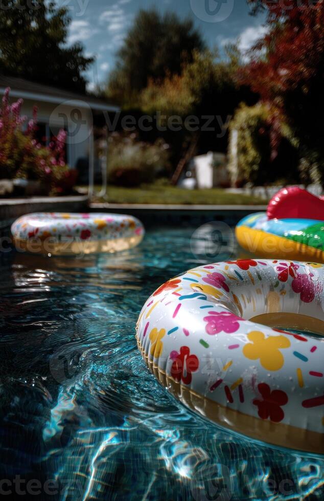 Inflatable Doughnut Pool Floats in Backyard Swimming Pool on Summer Day photo