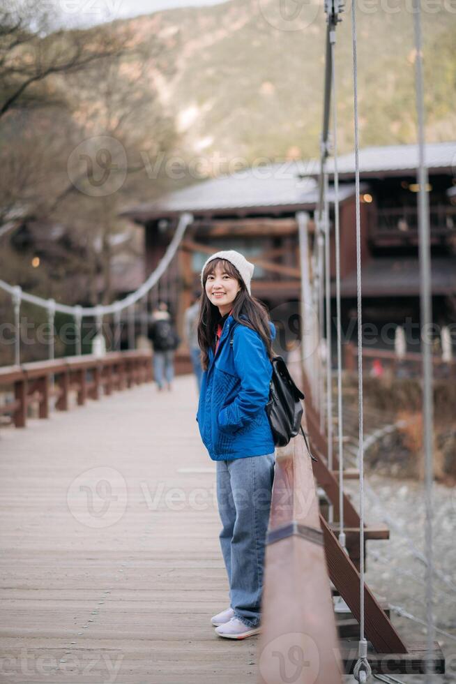 A girl in a blue jacket standing on a bridge photo