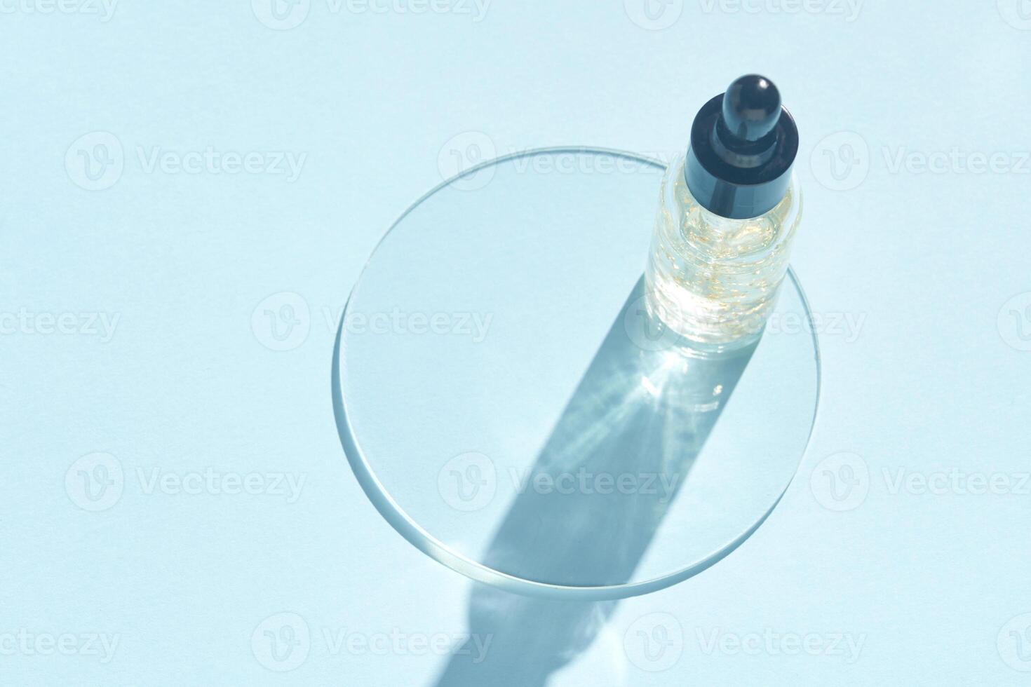 Minimalist skincare serum bottle with dropper casting shadow on light blue background. photo