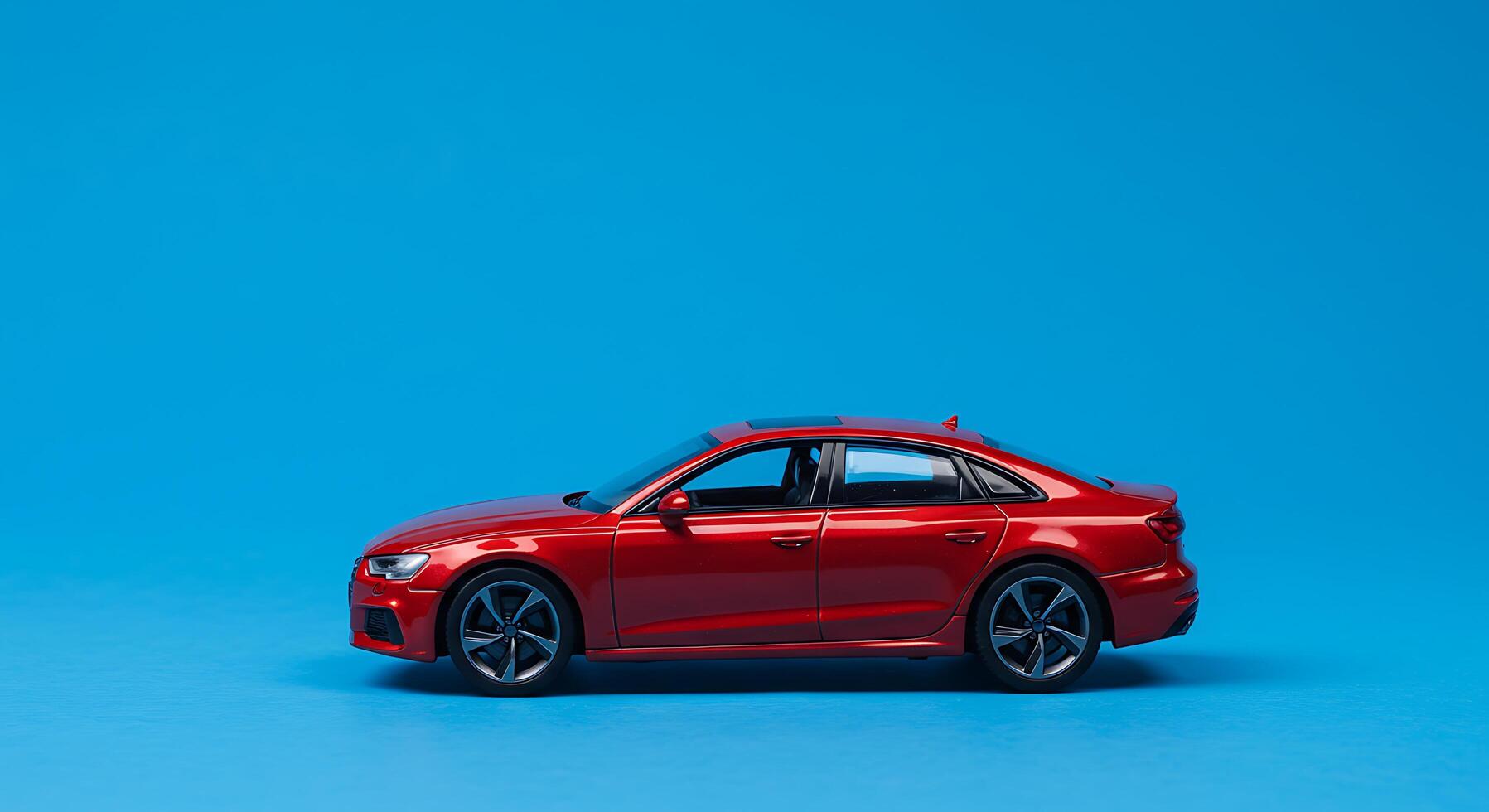 A red toy car on a blue background photo