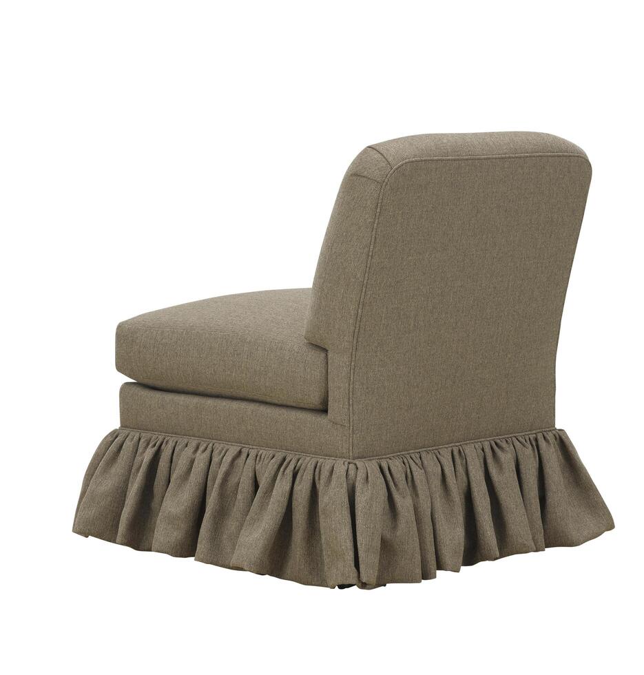 Studio shot of single upholstered armchair with ruffled skirt detailing photo