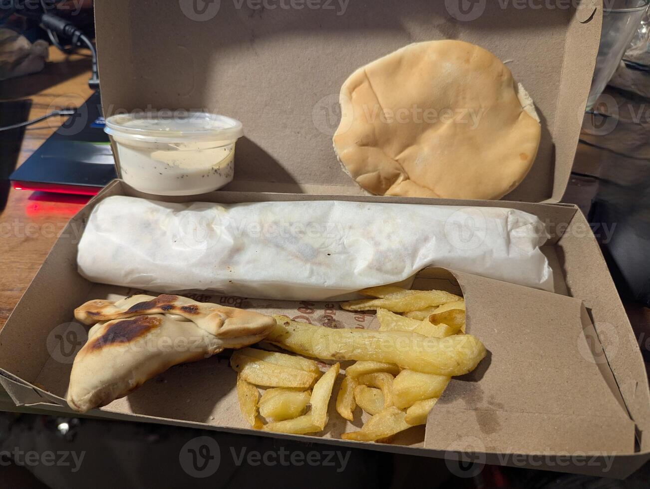 Empanada is a traditional Argentine dish. Empanadas, French fries and cheese sauce in a delivery box photo